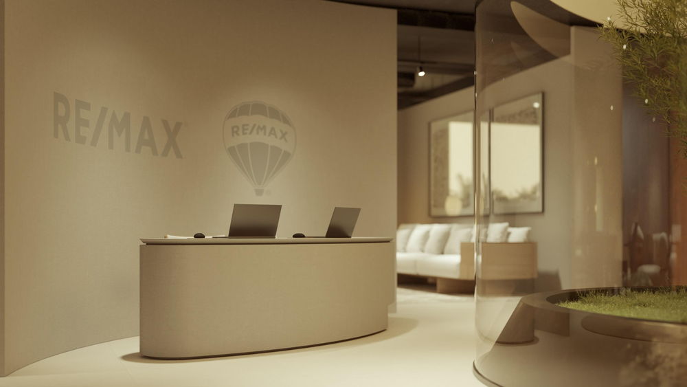 Projeto de loja: balcão de recepção curvo diante da parede com a marca RE/MAX