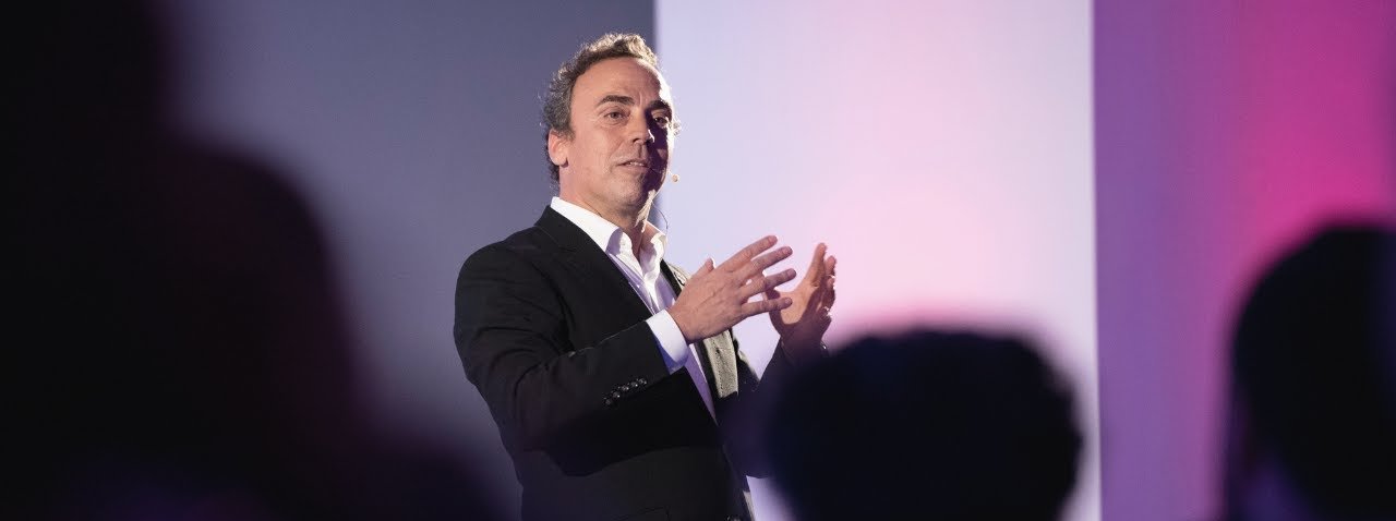 Pedro Fonseca no palco, falando e gesticulando para a plateia